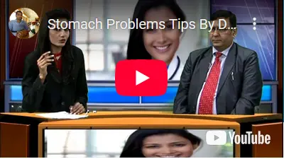 Dr Rajesh Kapoor with news anchor in their studio talking about stomach problems. The background of the studio is an image of a healthcare professional