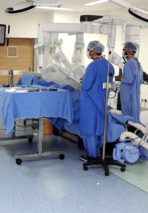Two men in surgical suits tending to a patient inside a surgery room